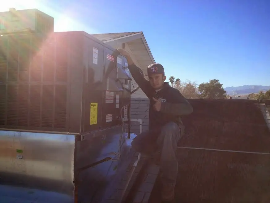 HVAC technician performing HVAC Inspection on a rooftop unit in University Park